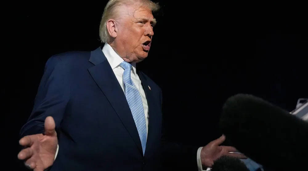 الرئيس الأميركي دونالد ترمب يتحدث للصحافيين قبل صعوده إلى طائرة الرئاسة في مطار بالم بيتش في طريق عودته إلى البيت الأبيض الأحد (أ.ب)