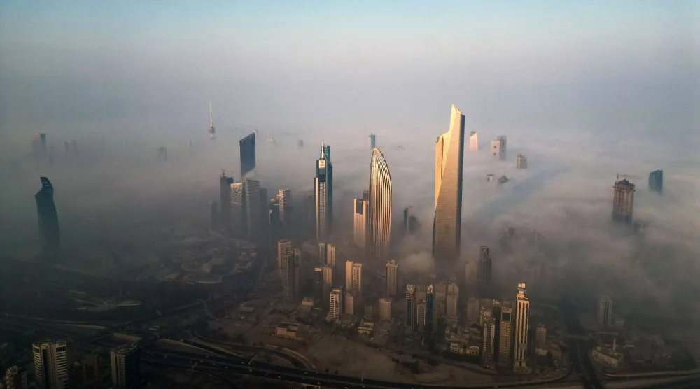 صورة جوية تظهر ناطحات سحاب وسط ضباب الصباح في مدينة الكويت (أ.ف.ب)