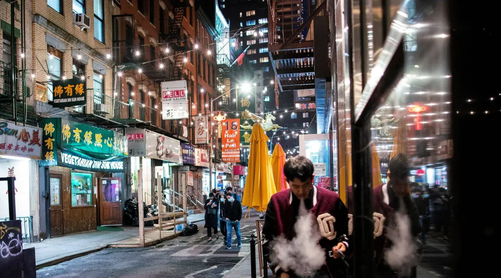 يمشي الناس في شارع محلي بمنطقة تشاينا تاون في حي مانهاتن بمدينة نيويورك (رويترز)