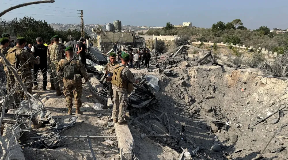 Lübnan askerleri, Güney Lübnan'daki Abbasiye kasabasında İsrail hava saldırısının hedef aldığı bir bölgede toplanıyor (Reuters)