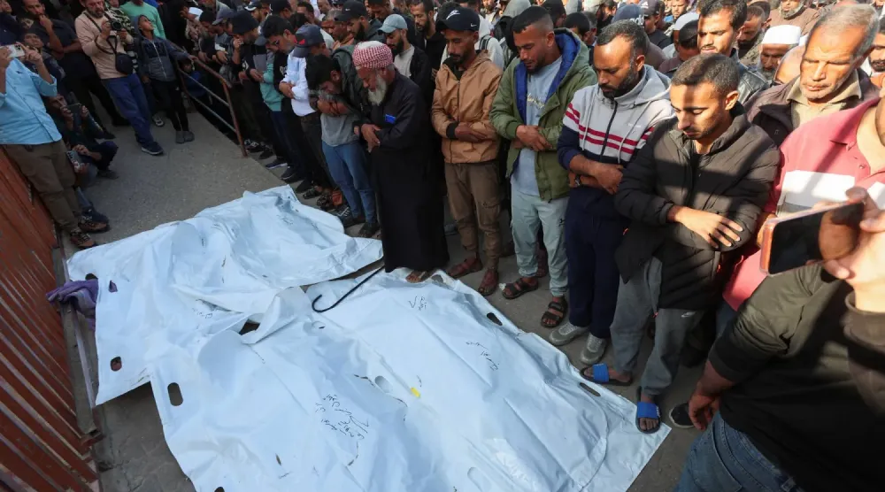 Gazze Şeridi'nin güneyindeki Han Yunus'ta bulunan Nasır Hastanesi'nde İsrail saldırısı sonucu hayatını kaybedenlerin cenaze namazını kılan Filistinliler (Reuters)