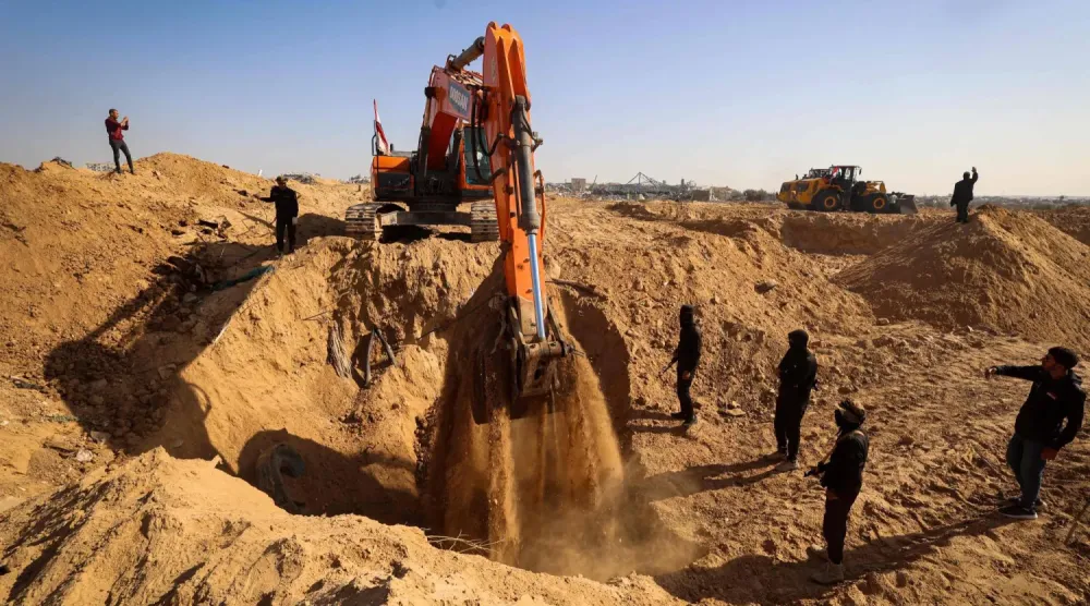 İslami Cihat savaşçıları ve Mısırlı işçiler, iki ağır araçla Cuma günü Gazze Şeridi'nin kuzeyindeki Nuseyrat'ta kaçırılanların cesetlerini arıyor (AP)