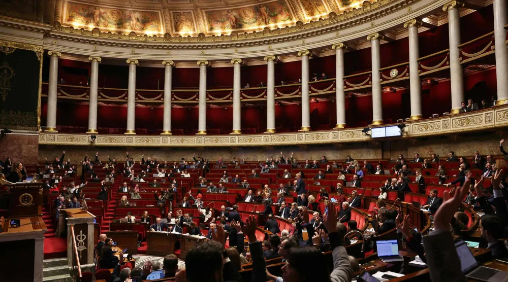 أعضاء البرلمان يرفعون أيديهم خلال جلسة مناقشة مشروع قانون الموازنة لعام 2026 في الجمعية الوطنية (أ.ف.ب)