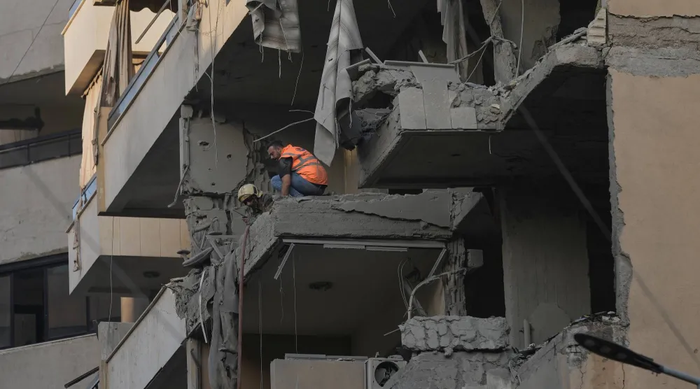 عناصر بـ«الدفاع المدني» في المبنى الذي استهدف بهجوم إسرائيلي في الضاحية الجنوبية لبيروت (أ.ب)