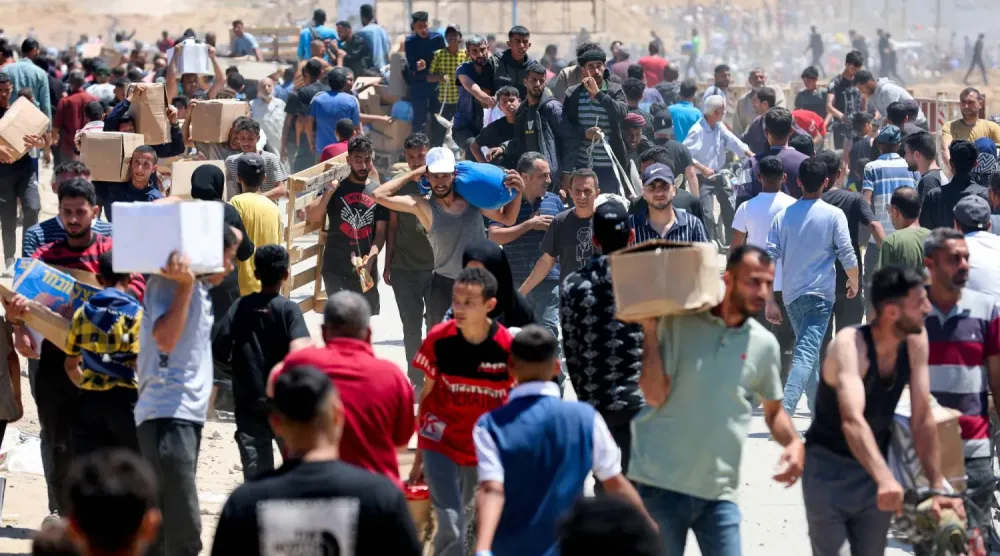 Filistinliler, 29 Mayıs 2025'te Gazze'nin merkezinde ABD destekli Gazze İnsani Yardım Vakfı'ndan aldıkları yardımı taşıyor (Reuters)