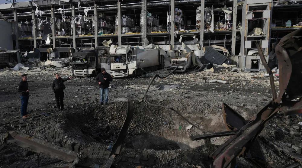 ضباط إنفاذ القانون يفحصون حفرة بجوار مركز اللوجيستيات المتضرر بشدة لسوبر ماركت في أعقاب الضربات الروسية على كييف 25 نوفمبر 2025 (أ.ف.ب)