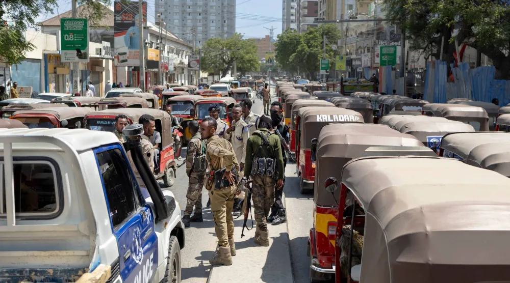  ضباط شرطة صوماليون يسيرون على طول حاجز وسط الطريق أثناء دوريتهم في شارع مزدحم بمقديشو 10 نوفمبر 2025 (أ.ف.ب)