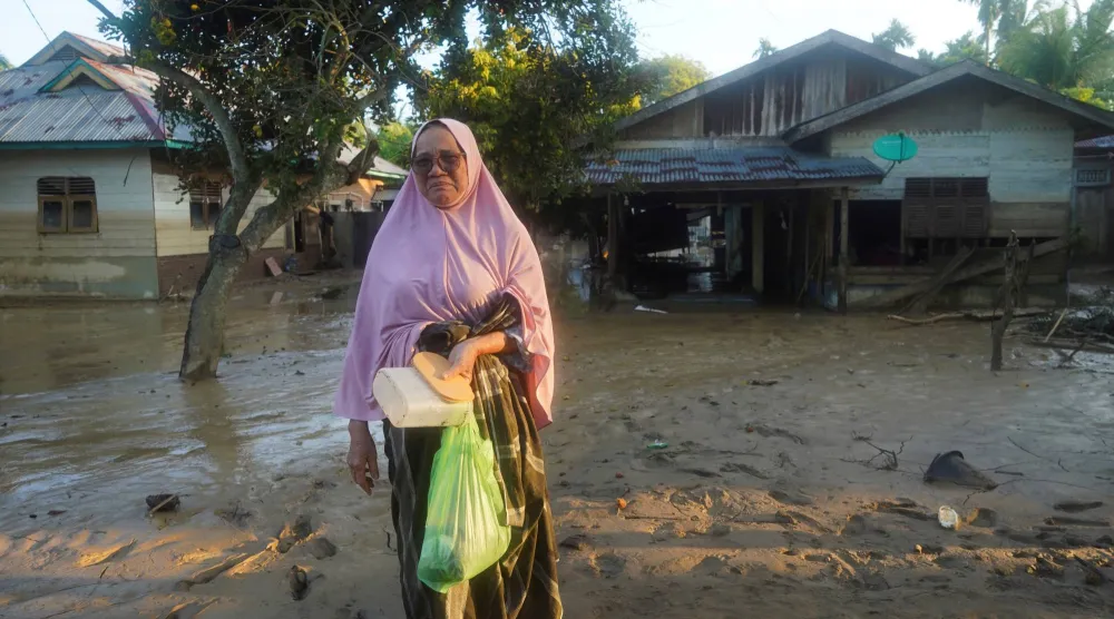 امرأة أثناء زيارتها لمنطقة ضربتها فيضانات مفاجئة مميتة عقب هطول أمطار غزيرة في منطقة بيروين (رويترز)