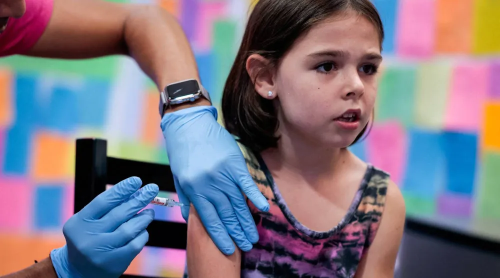 طفلة تتلقى جرعة من لقاح «موديرنا» لفيروس «كورونا» بصيدلية سكيباك في شوينكسفيل - بنسلفانيا (رويترز)