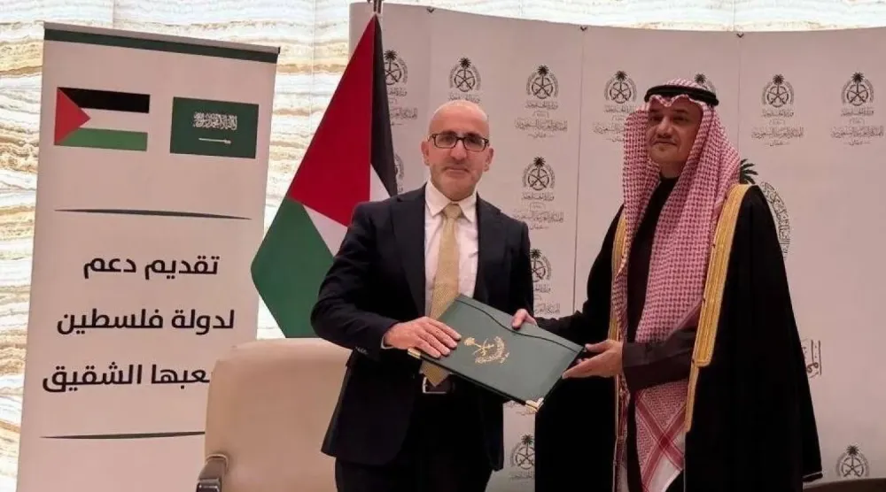 Prens Mansur bin Halid, Amman'daki büyükelçilik binasında Bakan Estephan Anton Selame’ye Suudi Arabistan'ın hibesini takdim ederken (WAFA)