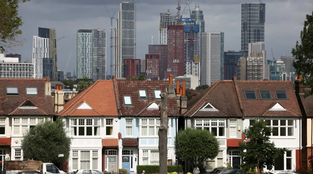 مبانٍ سكنية شاهقة قيد الإنشاء خلف صف من المنازل في جنوب لندن (رويترز)
