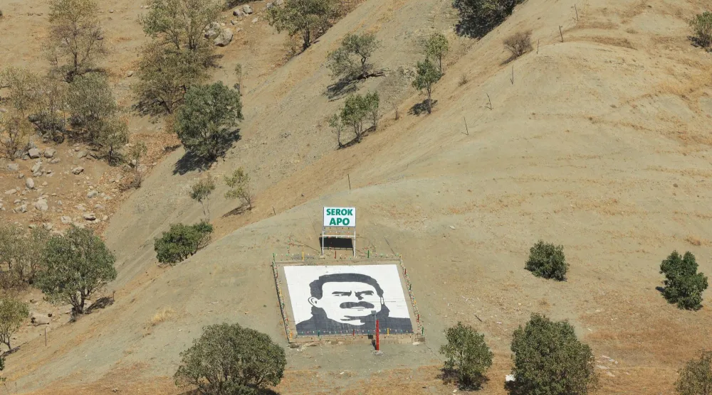 صورة لزعيم حزب العمال الكردستاني السجين عبد الله أوجلان ثبتها مسلحون من الحزب عند سفح جبل قنديل شمال العراق عند إعلان انسحابهم من تركيا في 26 أكتوبر الماضي (رويترز)