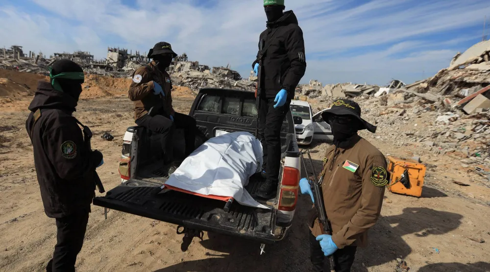 مسلحون من حركتي «حماس» و«الجهاد» يعثرون على جثة خلال عملية البحث عن جثث الرهائن القتلى في بيت لاهيا شمال قطاع غزة (رويترز)