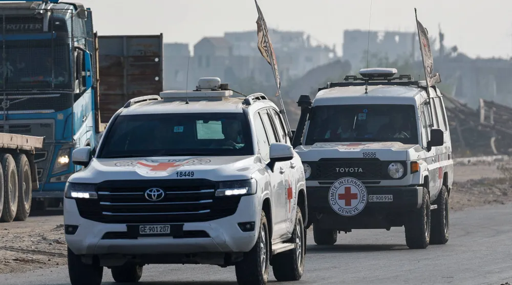 سيارات الصليب الأحمر تنقل رفات الضابط الإسرائيلي هدار غولدن في دير البلح (أرشيفية - رويترز)