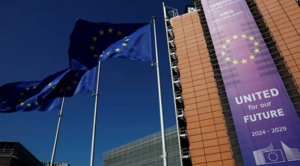 أعلام الاتحاد الأوروبي ترفرف أمام مقر المفوضية في بروكسل (رويترز)