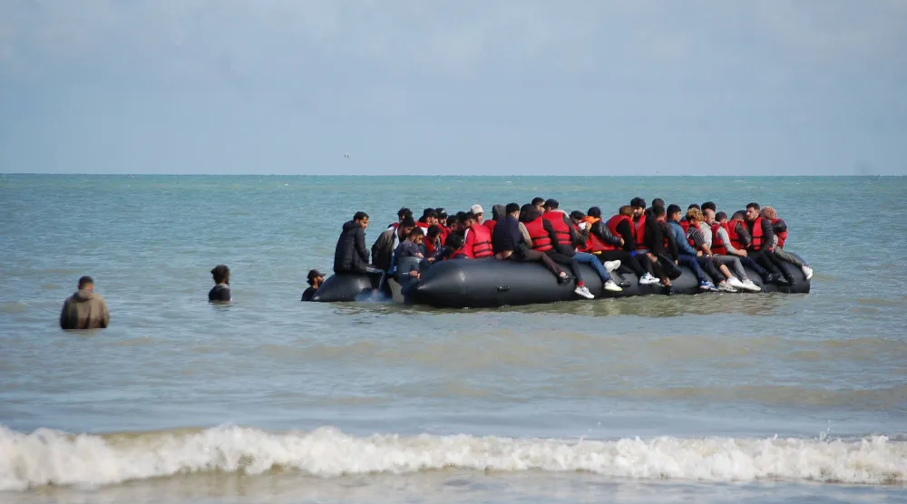 TOPSHOT - Migrants sit onboard an inflatable boat before attempting to illegally cross the English Channel to reach Britain, off the coast of Sangatte, northern France, on July 18, 2023. (Photo by BERNARD BARRON / AFP)