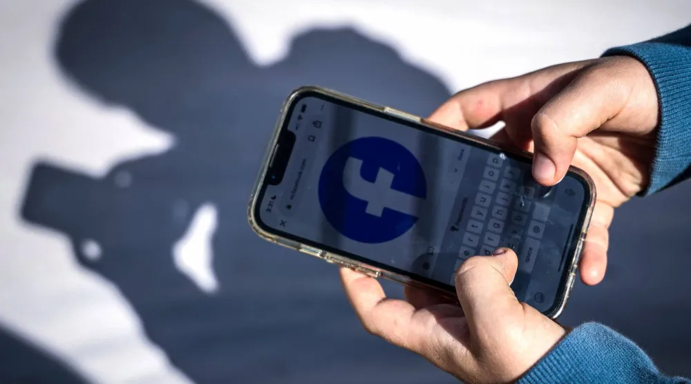 (FILES) This photo taken on October 24, 2025 shows a 14-year-old boy posing at his home near Gosford as he looks at social media on his mobile phone. (Photo by David GRAY / AFP)
