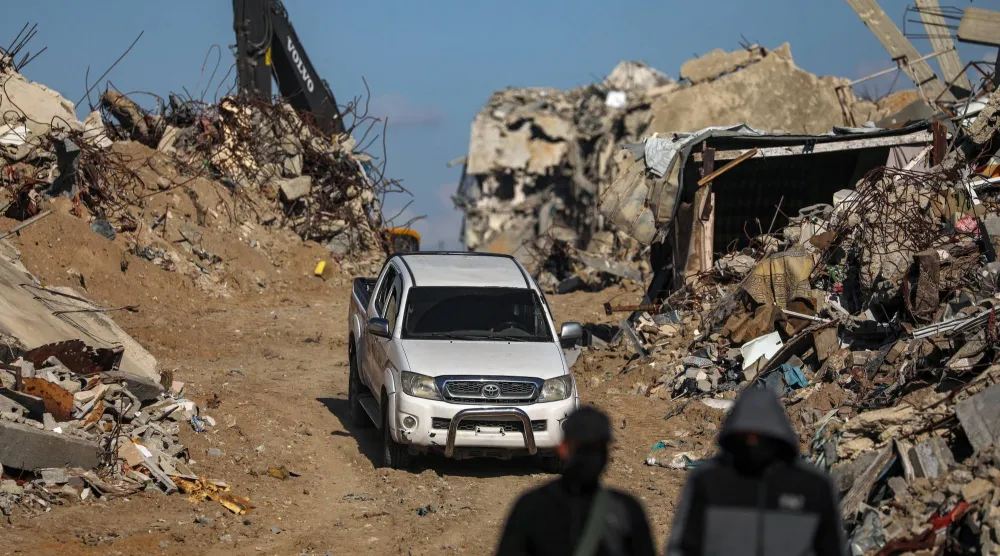 مقاتلون من «كتائب القسام» الجناح العسكري لحركة «حماس» يقفون حراساً أثناء البحث عن جثث رهائن إسرائيليين إلى جانب عمال الصليب الأحمر وسط أنقاض مخيم جباليا للاجئين شمال قطاع غزة يوم 1 ديسمبر 2025 (إ.ب.أ)