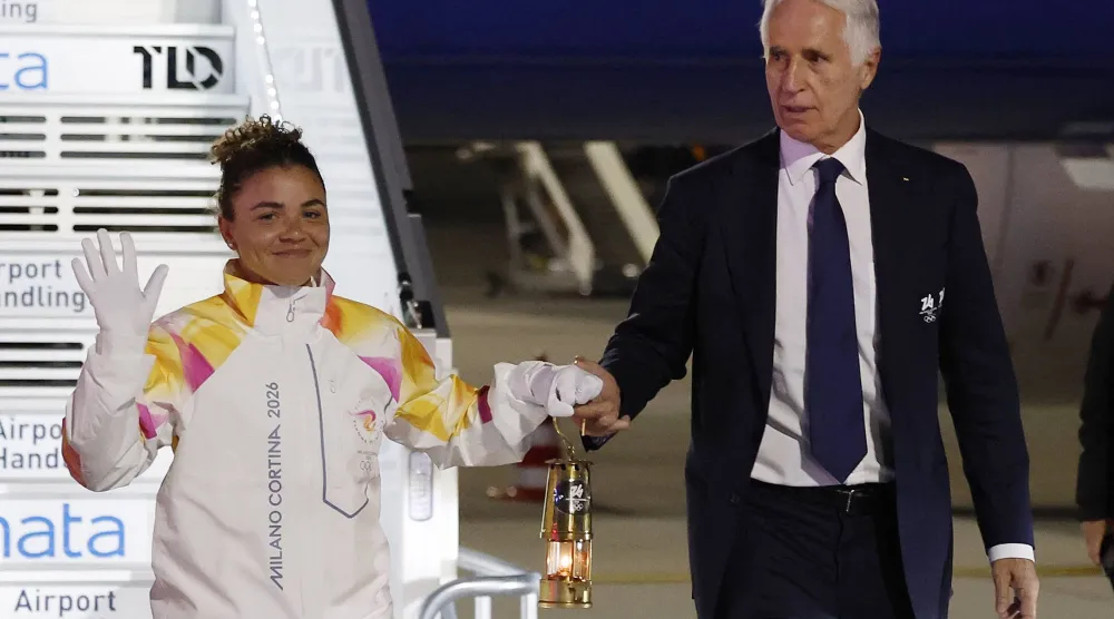 Olympics - 2026 Milano-Cortina Winter Olympics - Olympic torch due to arrive at Rome airport and Italian Presidential Palace - Rome, Italy - December 4, 2025 President of the Milano Cortina 2026 Organizing Committee, Giovanni Malago and tennis player Italy's Jasmine Paolini arrive with the Olympic torch REUTERS/Remo Casilli