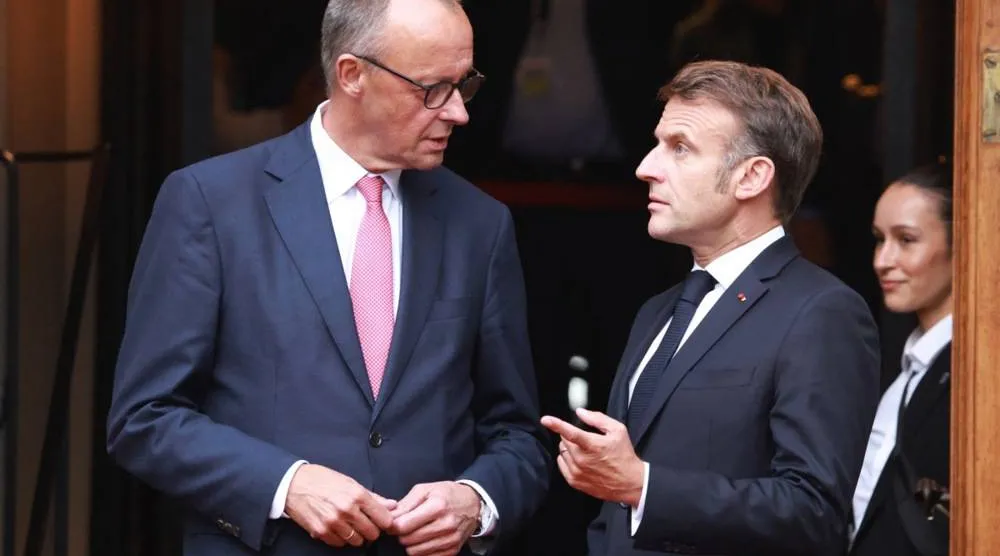 المستشار الألماني فريدريش ميرتس والرئيس الفرنسي إيمانويل ماكرون يتحدثان في برلين بألمانيا يوم 23 يوليو 2025 (إ.ب.أ)