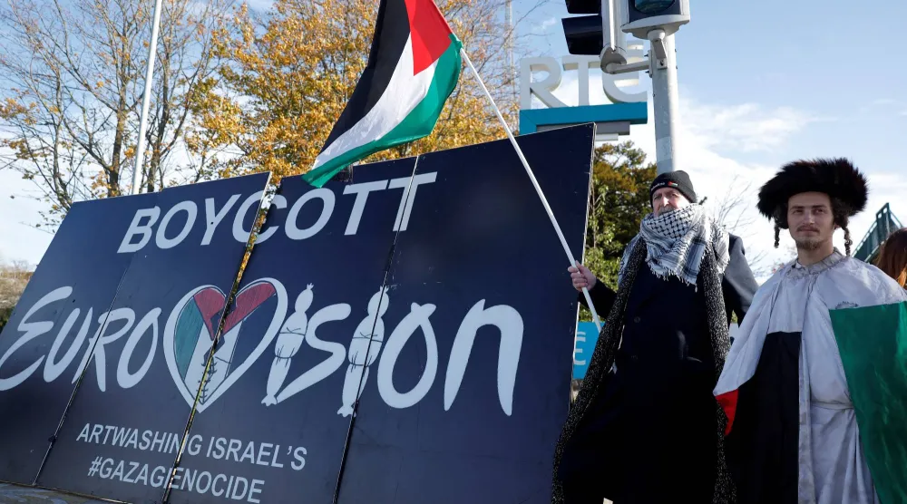Pro-Palestinian protestors hold a flag and a banner outside the RTE (Radio Telefis Eireann) Irish public service broadcaster television studios as demonstrators call for an Irish boycott of the 2026 Eurovision Song Contest if there is Israeli participation, in Dublin, Ireland, November 1, 2025. (Reuters)