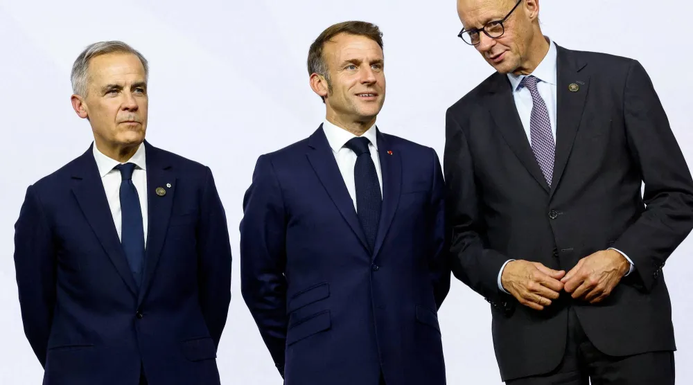 المستشار الألماني ميرتس مع الرئيس الفرنسي ماكرون ورئيس الوزراء الكندي كارني (رويترز)