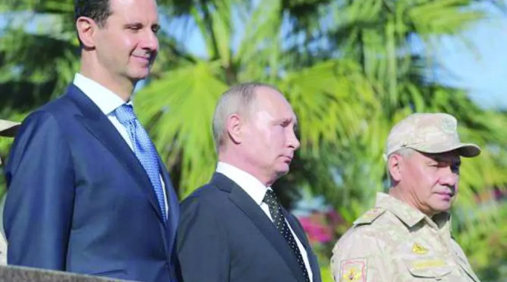 بوتين والأسد يحضران عرضاً عسكرياً في القاعدة الجوية الروسية «حميميم» قرب اللاذقية ديسمبر 2017 (أ.ف.ب)