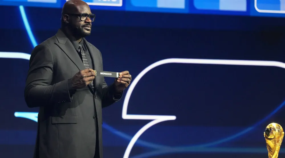 أونيل نجم السلة المعتزل لحظة عرضه بطاقة المغرب خلال مراسم القرعة (أ.ب)