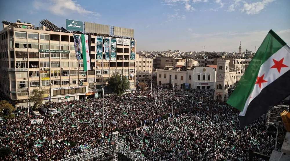 حشد كبير في ساحة العاصي بحماة أمس احتفالا بالذكرى السنوية الأولى لسقوط نظام بشار الأسد أمس (إ.ب.أ)