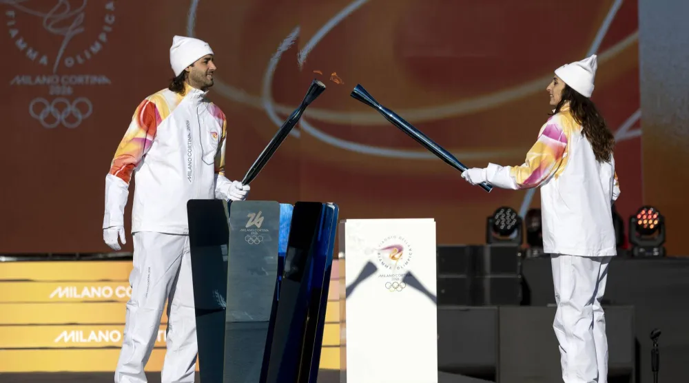 Italy's high jump athlete and torchbearer Gianmarco Tamberi (L) and Italy's former fencing athlete Elisa Di Francisca light the torch with the Olympic flame during the Torch Relay to Milano-Cortina 2026 Olympic Games, in Rome, Italy, 06 December 2025.  EPA/MASSIMO PERCOSSI