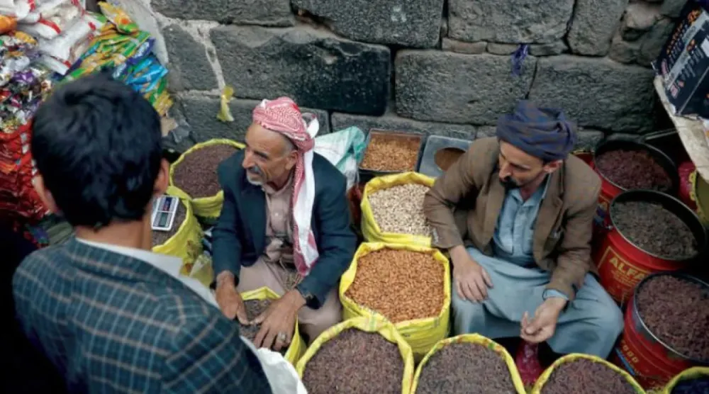 يمنيان يبيعان الحبوب المنتجة محلياً في سوق بوسط صنعاء (إ.ب.أ)