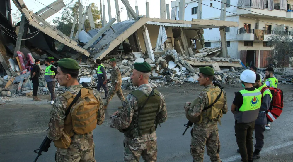 جنود من الجيش اللبناني أمام مبنى استُهدف بغارة جوية إسرائيلية في قرية دير كيفا جنوب لبنان الشهر الماضي (أ.ف.ب)