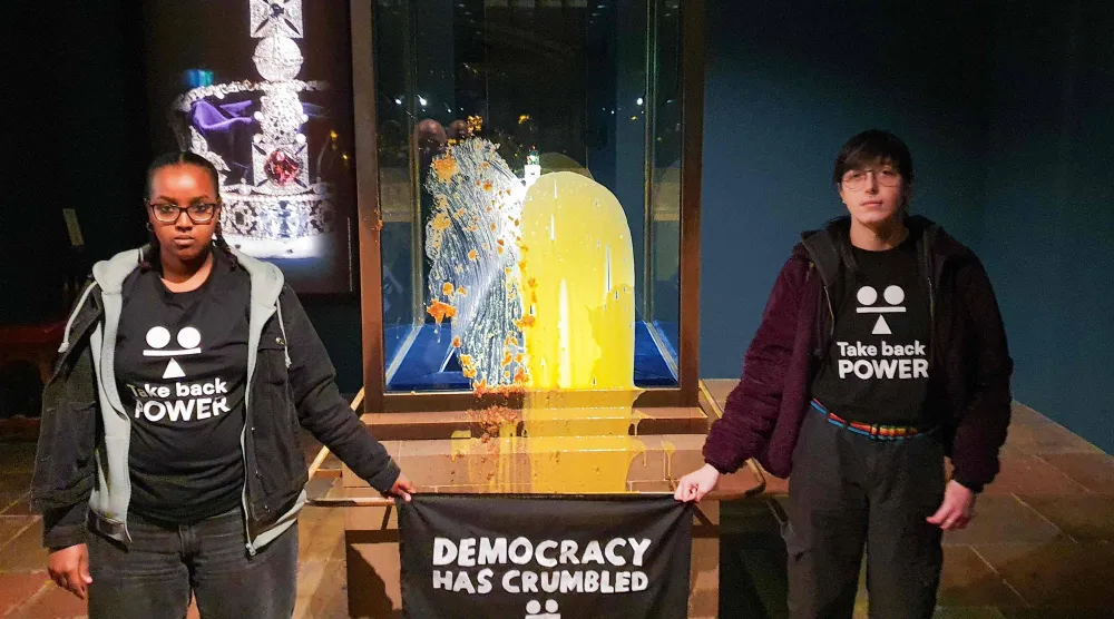 اثنان من أعضاء مجموعة تدعى «استعيدوا السلطة» لطخا صندوقاً يحتوي على تاج الدولة الإمبراطوري في لندن بفطيرة التفاح والكاسترد («استعيدوا السلطة» - أ.ف.ب)