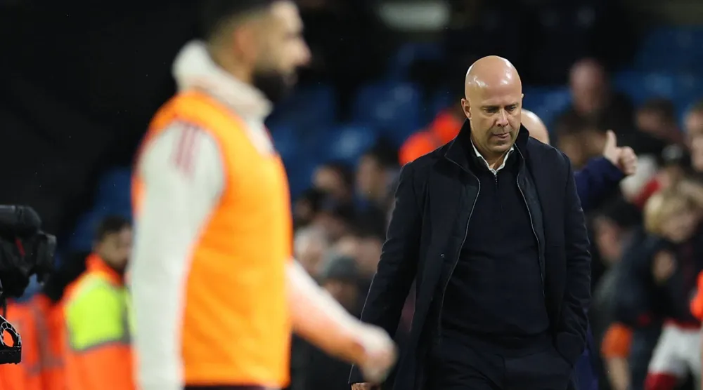 سلوت متحسرا عقب نهاية المباراة فيما يمر صلاح من أمامه (رويترز)