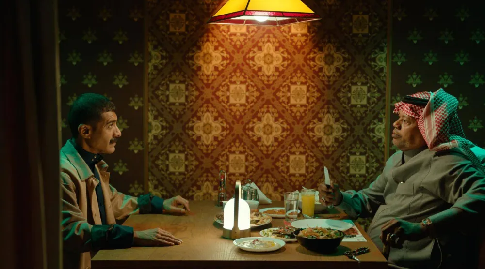 اللاعب المعتزل سعيد العويران في مشهد من الفيلم برفقة محمد الدوخي (نتفليكس)