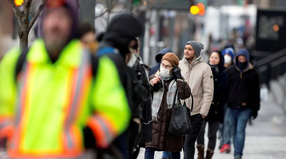 امرأة ترتدي الكمامة خلال فترة انتشار الجائحة في كندا (رويترز)