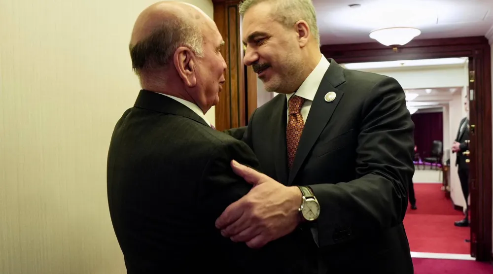 وزير الخارجية العراقي فؤاد حسين خلال مصافحة وزير الخارجية التركي هاكان فيدان على هامش منتدى الدوحة (الصفحة الرسمية لوزارة الخارجية العراقية بـ«فيسبوك»)