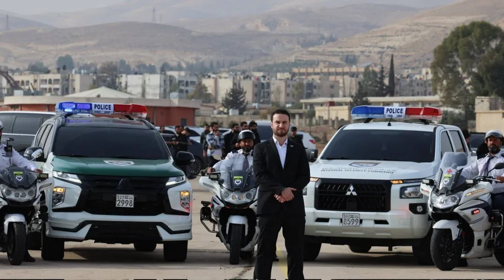 نور الدين البابا المتحدث باسم وزارة الداخلية وخلفه عدد من عناصر وسيارات الشرطة (حساب المتحدث باسم الداخلية السورية عبر منصة إكس)