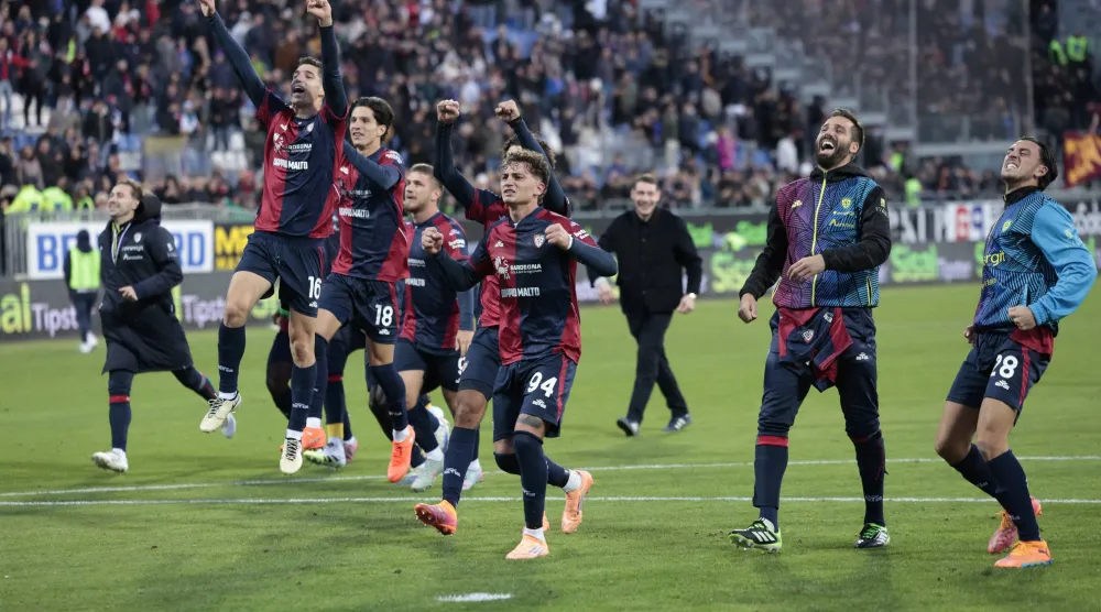 احتفالية لاعبي كالياري مع جماهيرهم بالفوز الغالي على روما (رويترز)