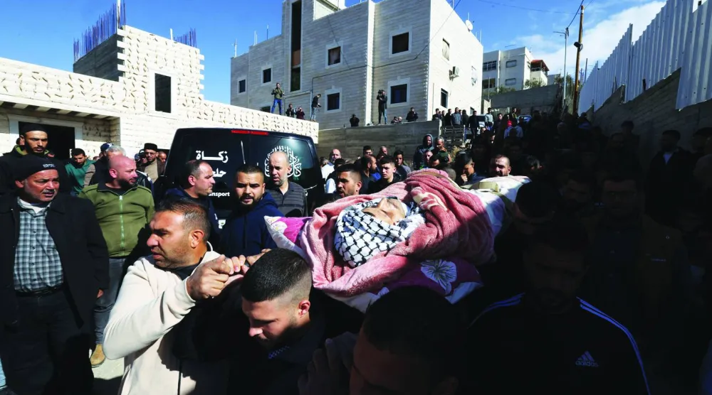 
فلسطينيون يحملون جثماناً لعامل قتلته إسرائيل في الخليل بالضفة الغربية المحتلة أمس (أ.ف.ب)