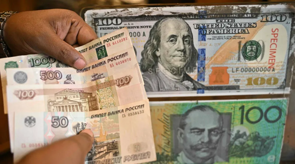 موظف يَعدّ أوراقاً نقدية من الروبل الروسي بمتجر لصرف العملات الأجنبية في بنغالورو (أ.ف.ب)