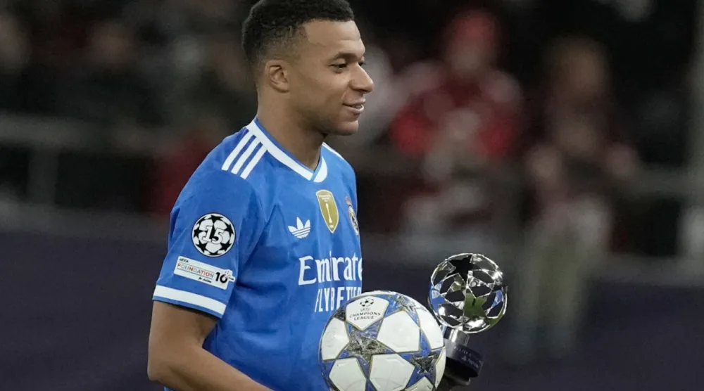 Real Madrid's Kylian Mbappe poses with the trophy after scoring four goal during the Champions League opening phase soccer match between Olympiacos and Real Madrid, in in Piraeus port, near Athens, Greece, Wednesday, Nov. 26, 2025. (AP Photo/Petros Giannakouris)