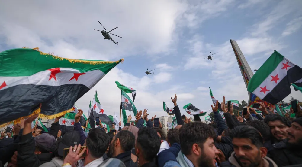 مروحيات للجيش تحلق في سماء المنطقة خلال عرض عسكري بمناسبة الذكرى الأولى لإطاحة نظام بشار الأسد في دمشق يوم الاثنين (أ.ب)