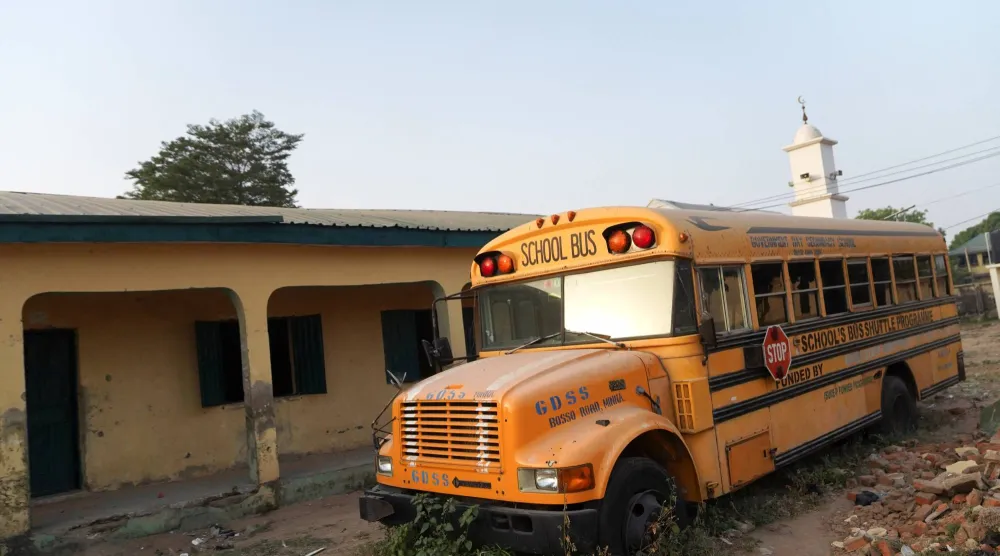 حافلة مدرسية تقف أمام فصول دراسية فارغة في مدرسة بولاية النيجر في نيجيريا (رويترز)