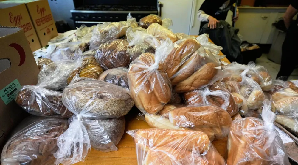 أكياس من الخبز تظهر على طاولة للأشخاص الذين يحتاجون إلى الطعام في شيكاغو (أ.ب)