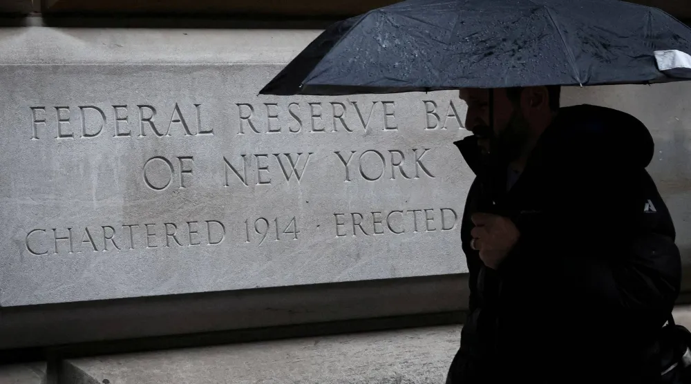 رجل يمر أمام بنك الاحتياطي الفيدرالي في نيويورك (رويترز)
