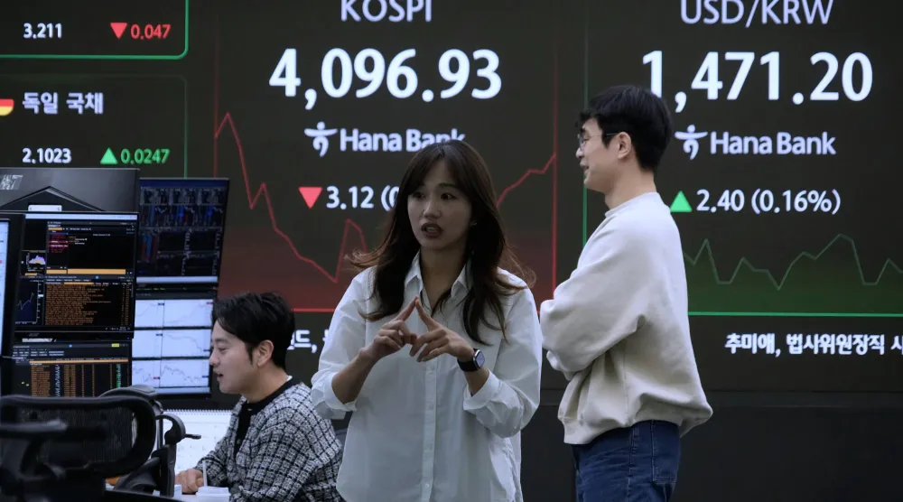 متداولون يعملون أمام شاشة تُظهر مؤشر كوسبي وسعر صرف الدولار مقابل الوون في مقر بنك هانا في سيول (أ.ب)