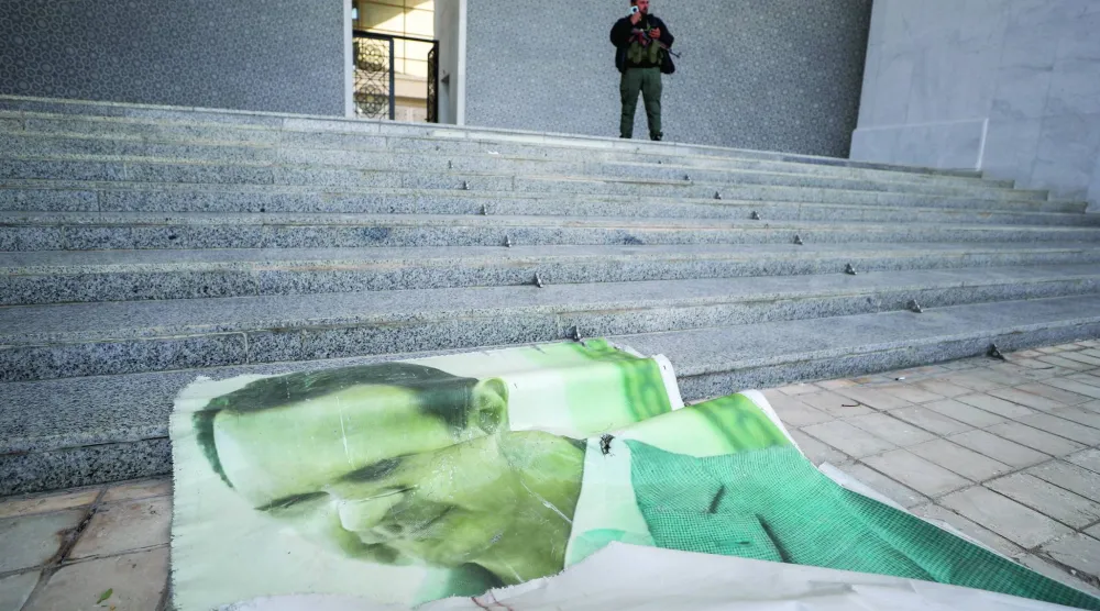 صورة ضخمة لبشار الأسد ملقاة على الأرض بعد هروبه على أرضية القصر الرئاسي في دمشق 8 ديسمبر 2024 (أ.ب)