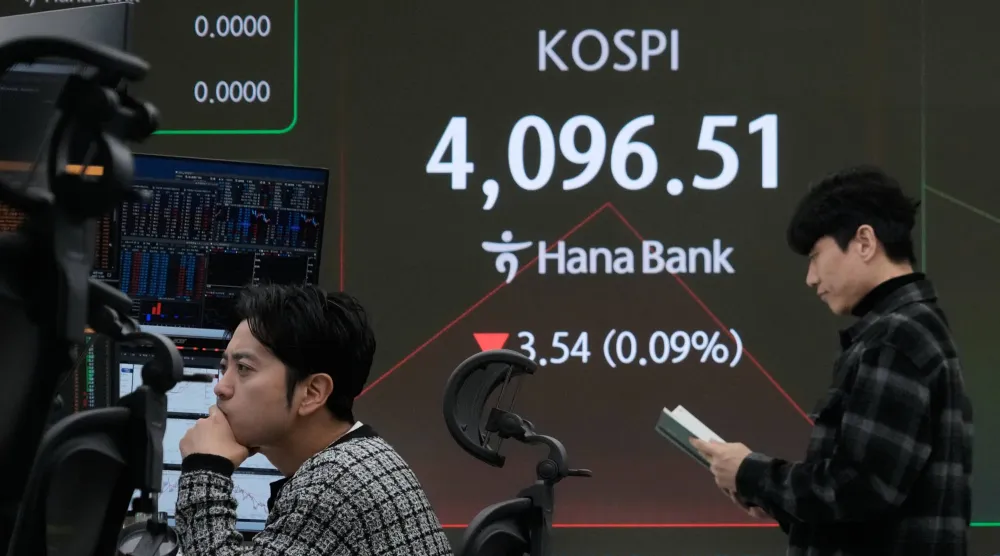 متداولون أمام شاشة تعرض مؤشر «كوسبي» في غرفة تداول بنك هانا في سيول (أ.ب)