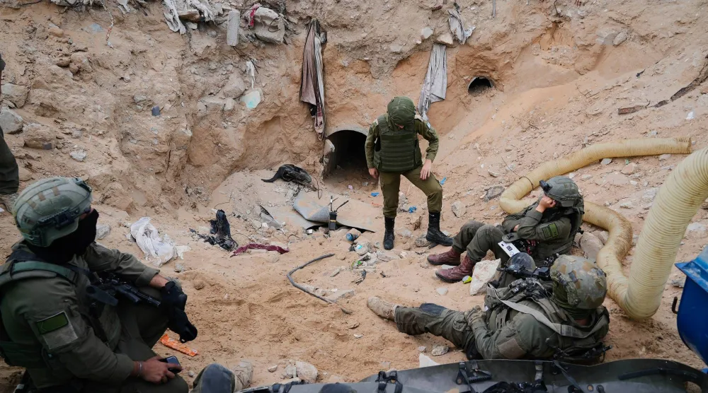 جنود إسرائيليون يقفون عند مدخل نفق في رفح بقطاع غزة قال الجيش الإسرائيلي إنه احتجز فيه جثمان الجندي هدار غولدين (أ.ب)